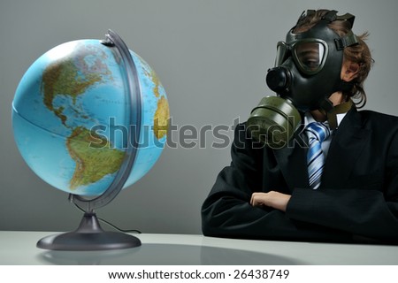 Businessman with gas mask on face looking at earth globe