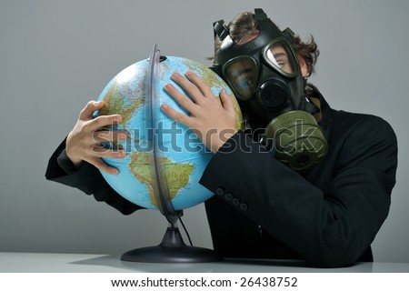 Businessman with gas mask on face holding earth globe