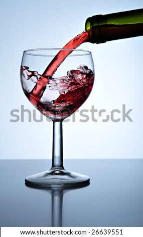 Red wine poured into wine glass, close up