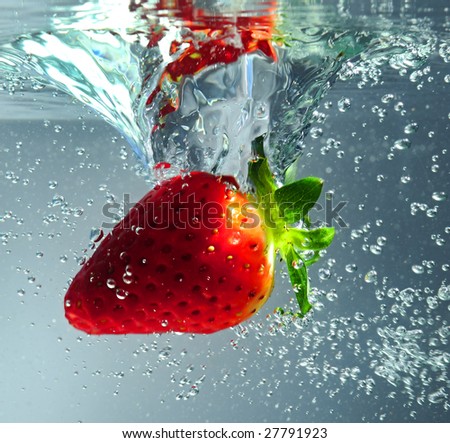 Strawberry falling in water, close up