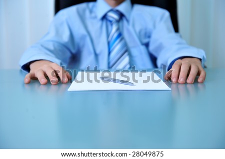 Desk detail with blank paper a pen and businessman hands