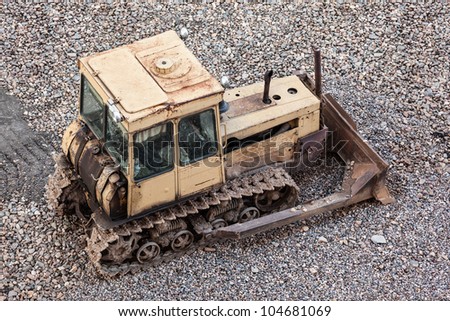 Old rusty earth digging caterpillar bulldozer machine working at building construction site