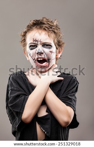 Halloween or horror concept - screaming walking dead zombie child boy reaching hand
