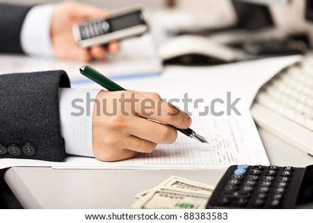 Working business man hand pen writing paper document at office workplace desk