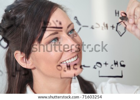 female writes out a chemistry equation.
