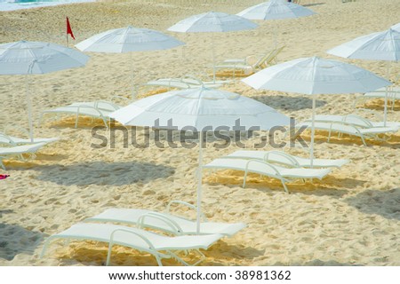 Zen beach made up of rows of white umbrellas and white lounging chairs made for relaxation and recreation in cancun mexico yucatan peninsula along the mayan coast