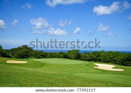 Golf course against deep blue sky with clouds and sand pools under white puffy clouds and the caribbean sun in tropical barbados in the western corner of the island