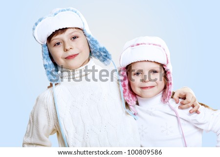Portrait of little kid in winter wear against blue background
