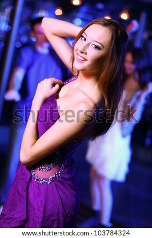 Young woman having fun and dancing at night club disco