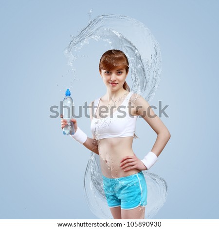 Portrait of a young woman doing sport with a bottle of pure water