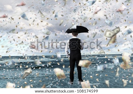 Young businessman standing with umbrella under money rain