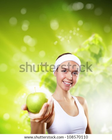Portrait of a young woman doing sport with a green apple