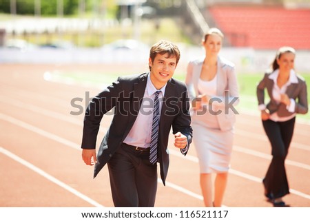 Businessmen running on track racing at athletich stadium