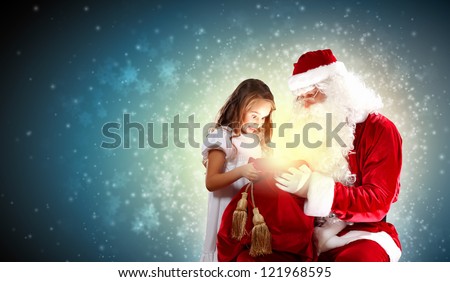 Portrait of Santa Claus with a little girl looking at a gift