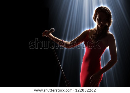 Female Singer On The Stage Holding A Microphone Stock Photo