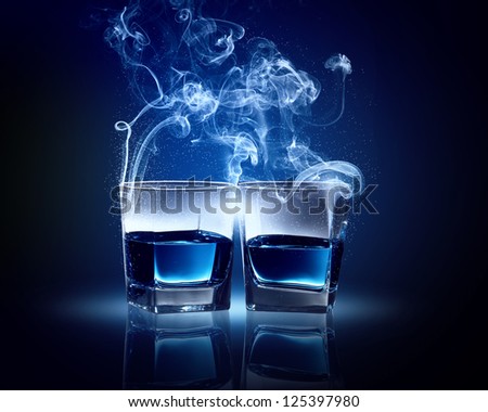 Two glasses o? blue cocktail with fume going out