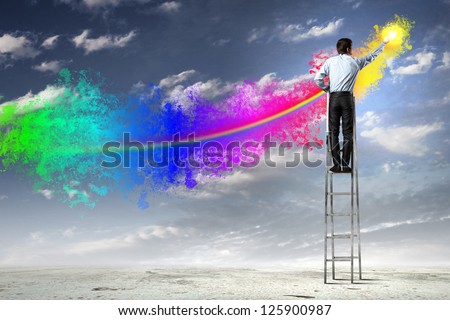 young man standing with back on ladder painting splashes