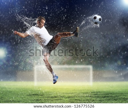 football player in white shirt striking the at the stadium under the rain