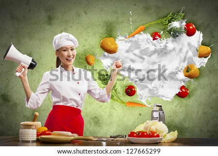Asian female cook holding megaphone vegetables flying in air