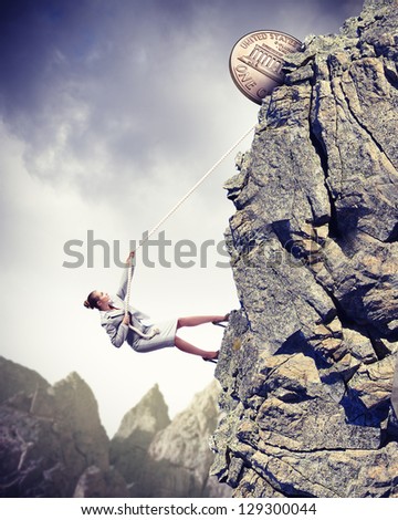 businesswoman climbing mountain with cent on top
