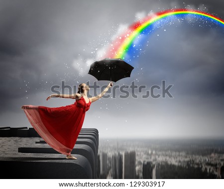 ballet dancer in flying satin dress with umbrella under the paint