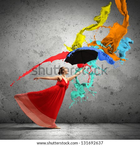 ballet dancer in flying satin dress with umbrella under the paint
