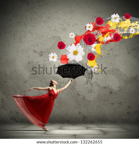 ballet dancer in flying satin dress with umbrella and flowers