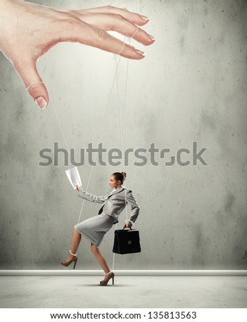 Businesswoman marionette on ropes controlled by puppeteer
