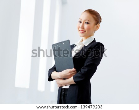 Image of young asian businesswoman in formal suit holding folder