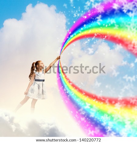 Image of little pretty girl drawing rainbow with finger