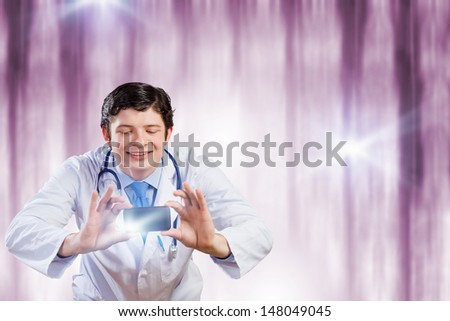 Young funny doctor taking photos with mobile phone camera
