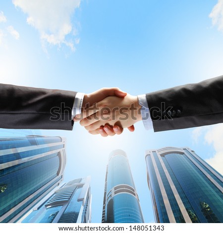 Close up image of hand shake against skyscrapers