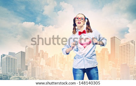 Young woman acting like super hero with heart sign on chest