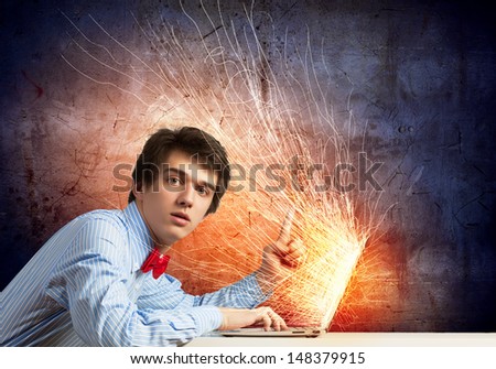 Image of young businessman at work using laptop