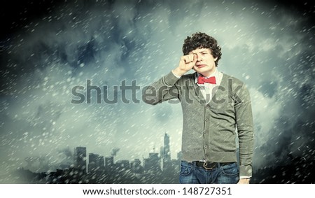 Image of young upset man in red tie crying