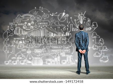Back view image of young businessman standing against business sketch