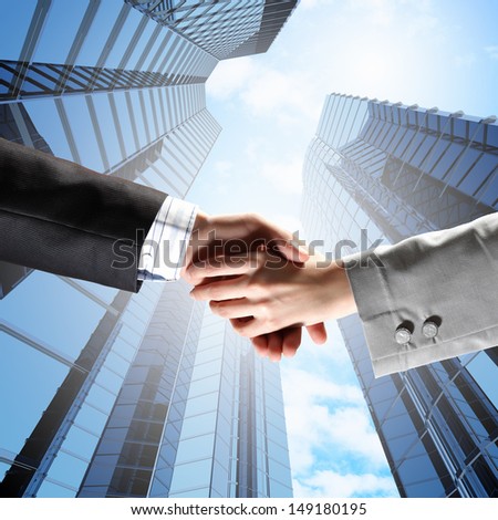 Close up image of hand shake against skyscrapers
