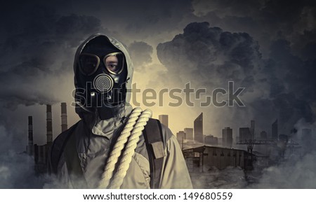 Man in gas mask against disaster background. Pollution concept