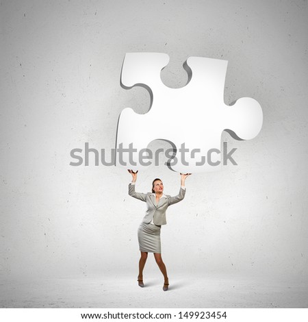 Image of businesswoman holding puzzle element above head
