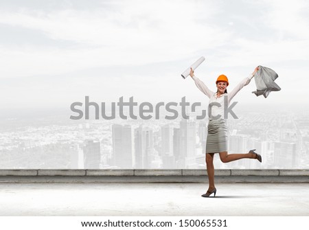 Young woman engineer in helmet jumping joyfully