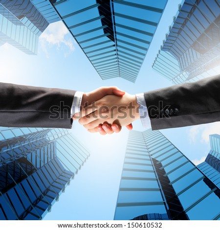 Close Up Image Of Hand Shake Against Skyscrapers