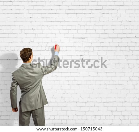 Back view image of businessman drawing on wall