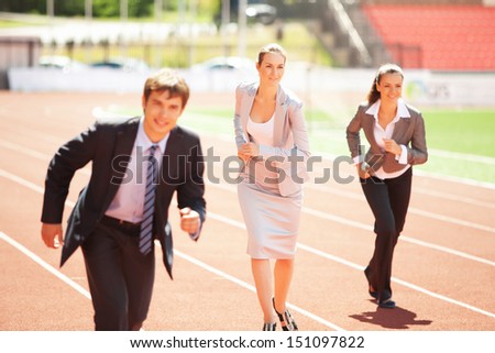 Businessmen running on track racing at athletich stadium