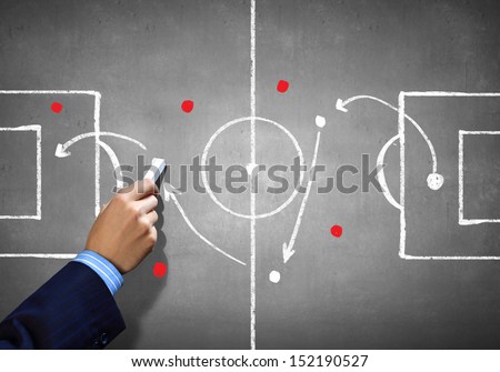 Close up image of human hand drawing football tactic plan