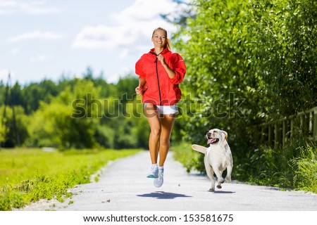 Young Attractive Sport Girl Running With Dog In Park