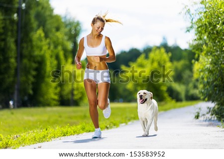 Young Attractive Sport Girl Running With Dog In Park