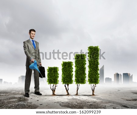 Image of businessman watering plant shaped like graph