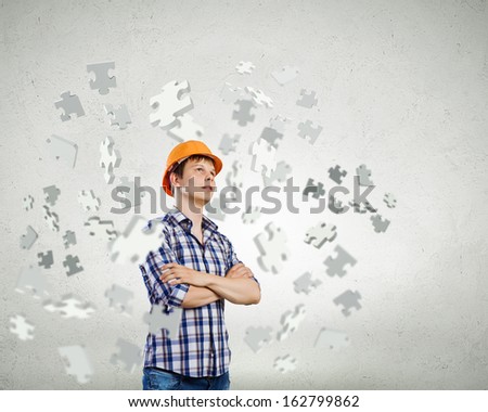 Image of thoughtful man builder with arms crossed on chest