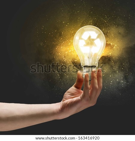 Image of human hand holding bulb with recycle symbol inside