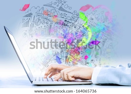 Close up image of laptop and human hands typing on keyboard